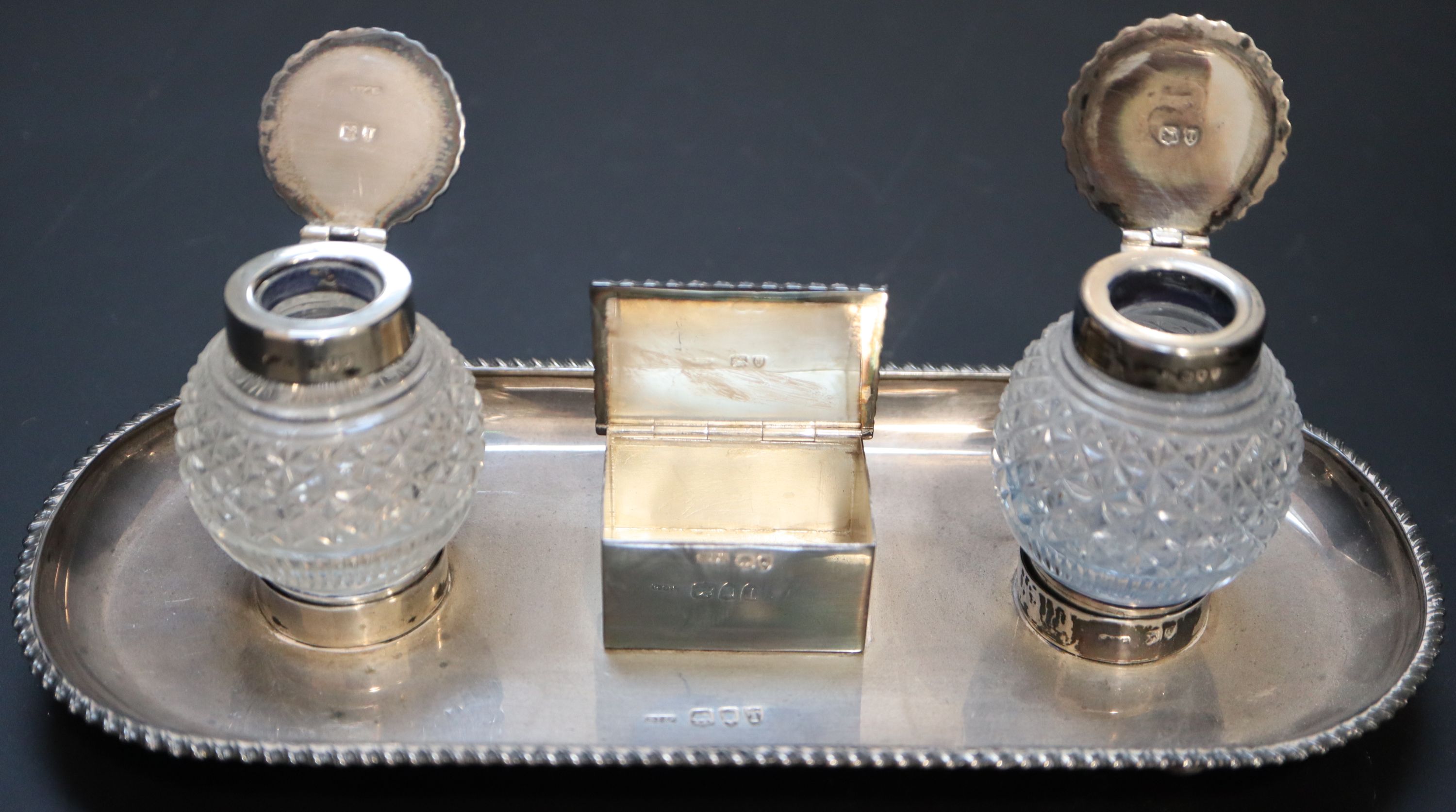 A late Victorian silver ovoid inkstand with two cut glass wells and central lidded compartment,